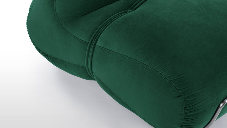 Elegant Detailing | The Bao Lounge Chair features a low-maintenance velvet in a deep green, contrasted by a gunmetal gray metal frame. The design is defined by the thick piping detail across the back and seat cushions.
