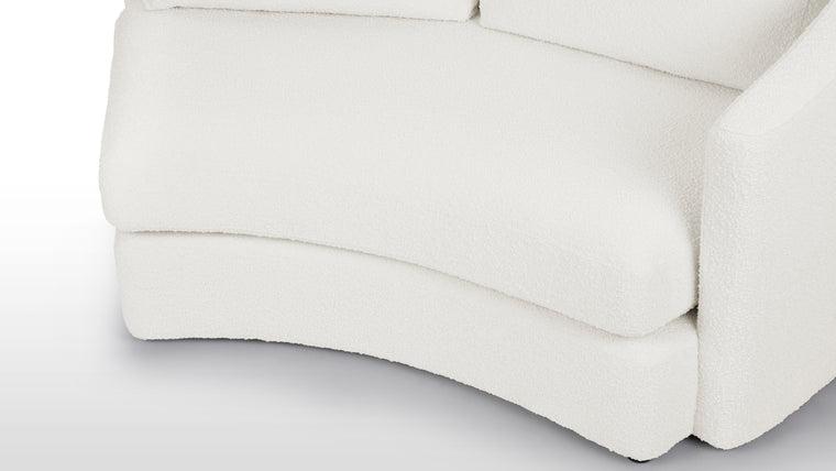 Textured Sophistication | Crafted from soft boucle fabric, the sectional exudes a tactile richness while maintaining a sleek European-inspired silhouette. The fabric’s warm white hue adds both comfort and contemporary visual appeal.
