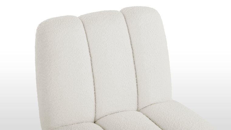 Textured Luxury | Wrapped in soft, plush white boucle fabric, this chair offers a rich sensory experience. Its discreet feet add stability without detracting from its refined, contemporary aesthetic.
