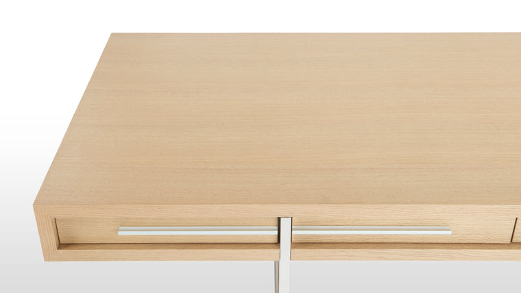 Stylish Details | In addition to a natural, oak veneer, the Naver Desk features stainless steel legs that are beautifully integrated into the desk’s form. It’s an open, airy base that helps lighten the overall look. 
