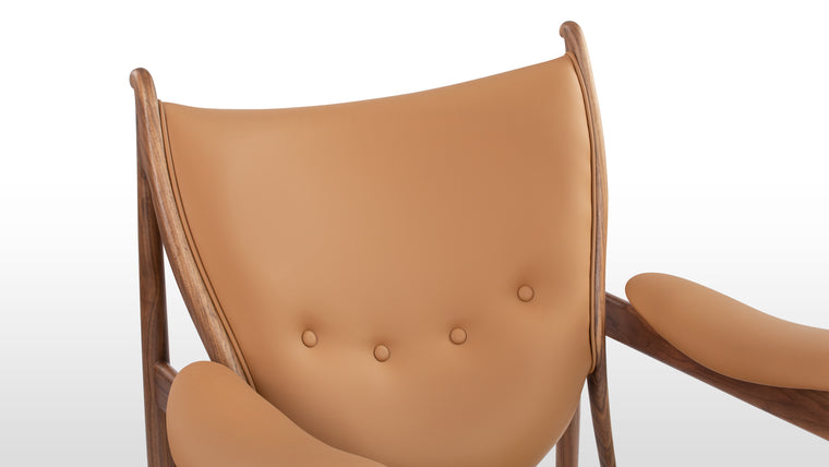 Rich Harmony | Combining the warmth of wood with the sophistication of vegan leather, the chair boasts a luxurious, sustainable blend. The four-buttoned backrest adds an artistic flourish to its refined design.
