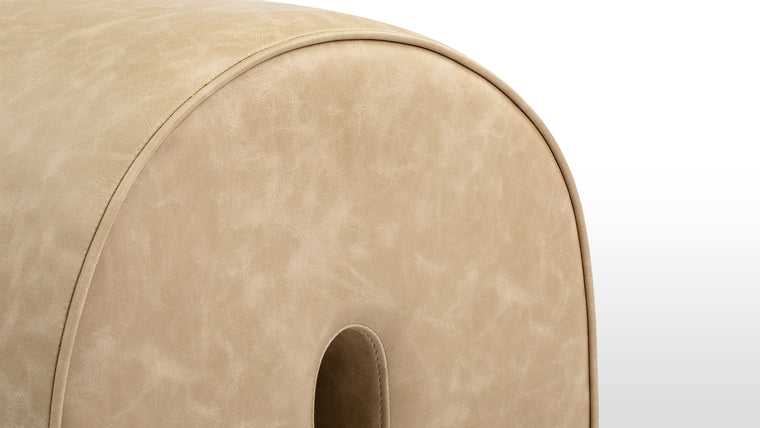 Soft and Sturdy | Crafted with soft vegan leather and a sturdy wooden frame, the Arch Ottoman embodies modern elegance. Its arched design and neutral beige tone offer a minimalist yet sophisticated aesthetic that blends seamlessly into diverse interiors.
