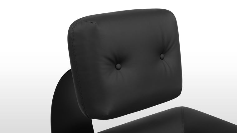 Bold Monochrome | Wrapped in vegan leather, supported by a powder-coated steel frame, and featuring a bold black monochrome look, this chair exudes sophistication with a futuristic edge.
